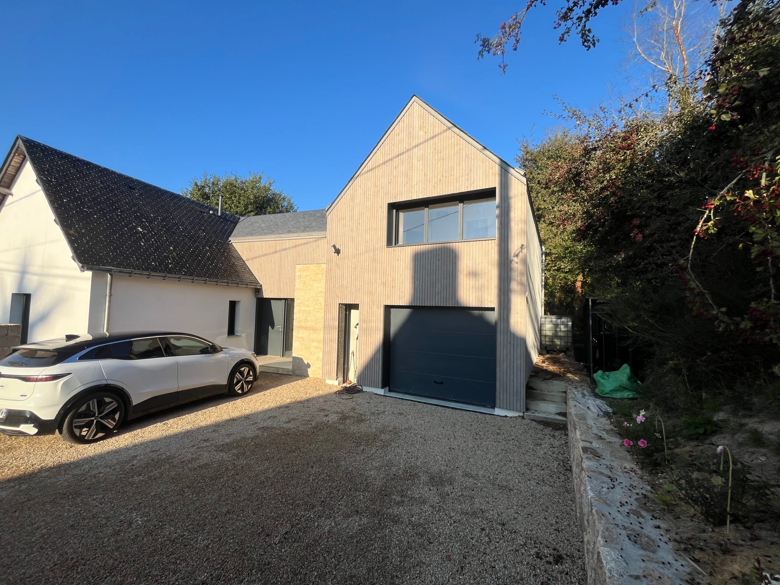 Maison contemporaine avec cour en gravier, clôture bois et mur en pierre, rénovation complète signée AJY Maçonnerie.