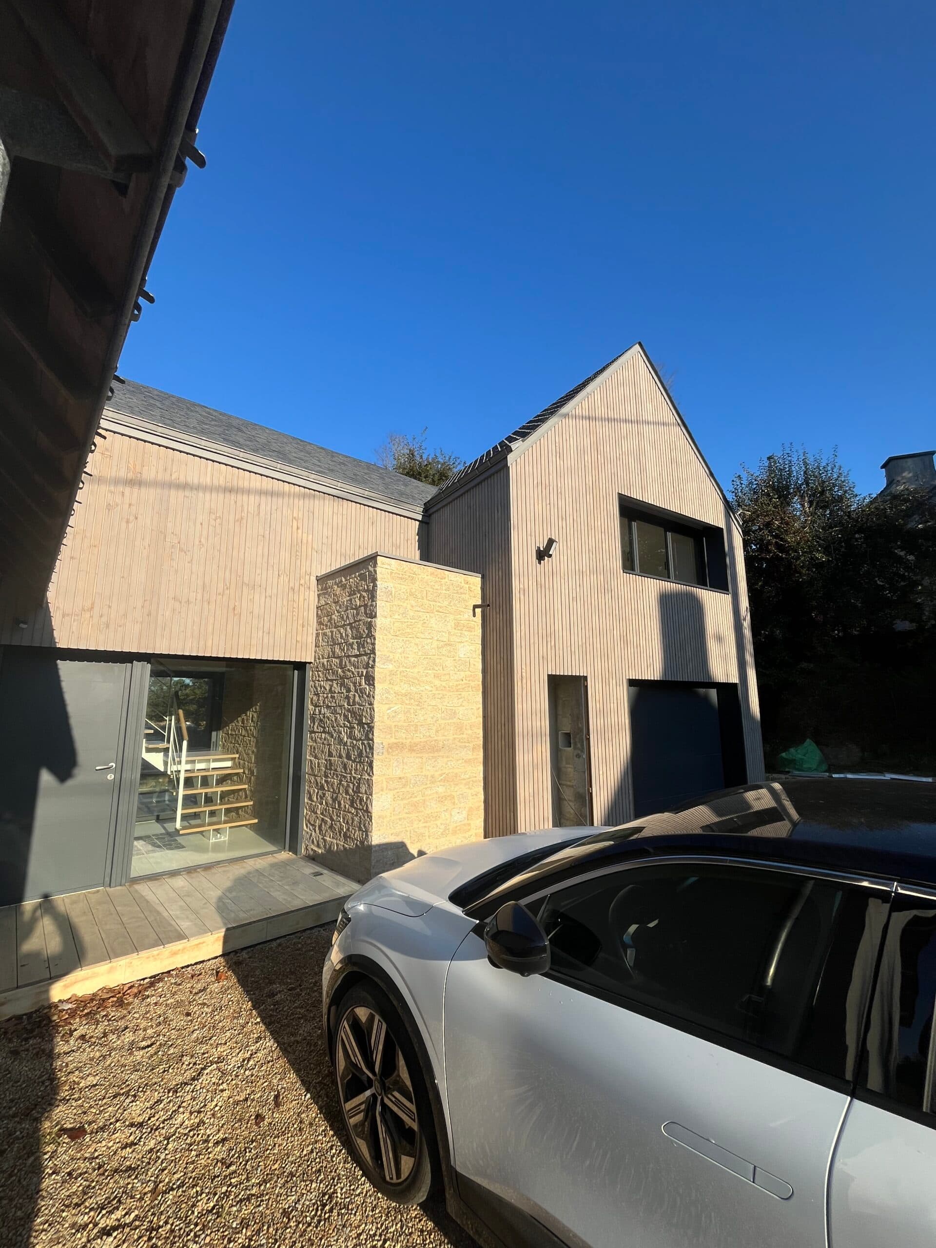 Vue arrière de maison rénovée mêlant pierre et enduit, chantier AJY Maçonnerie en cours de finition.