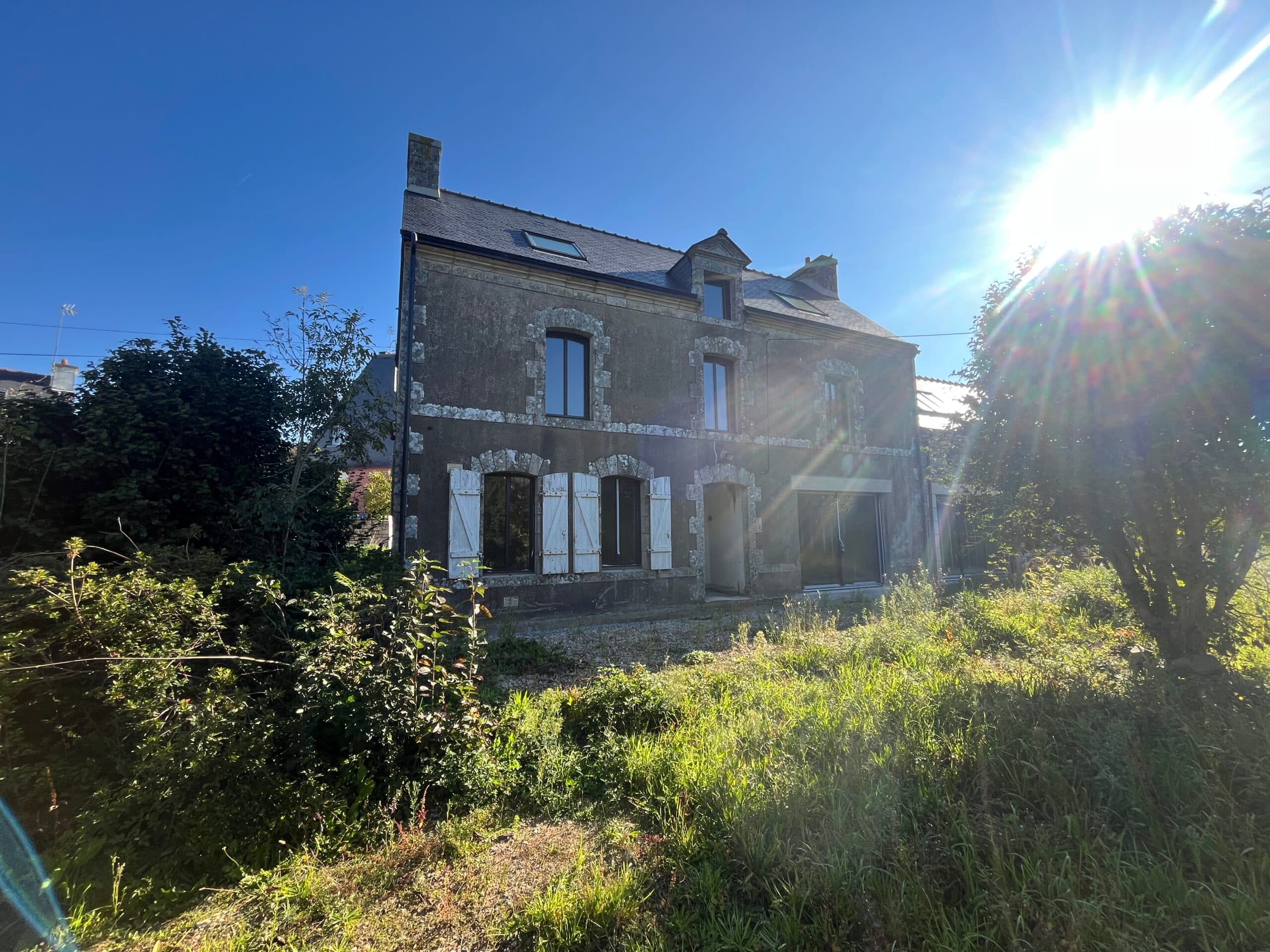 Vue latérale de la bâtisse en pierre mêlant ancienne maison et extension, démontrant le savoir-faire d’AJY Maçonnerie pour conserver le cachet d’origine.